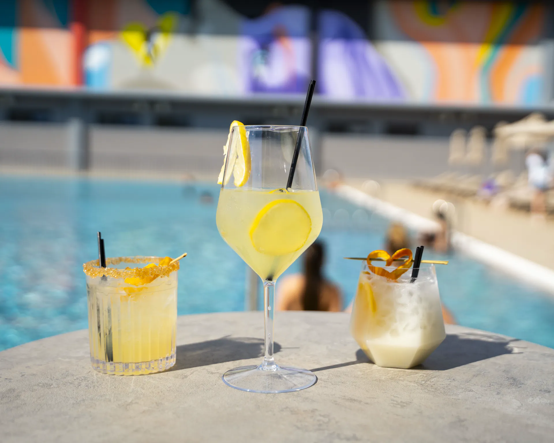Three cocktails on a table at the edge of the Coconut pool