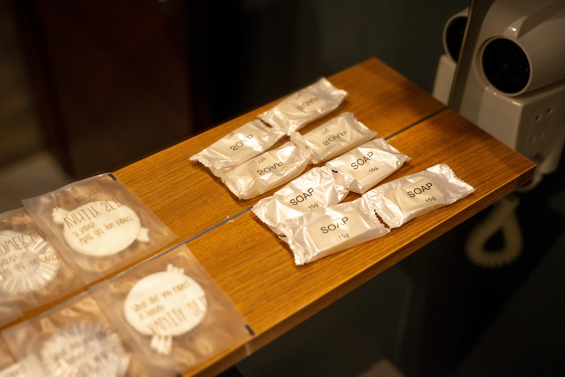 Wrapped toiletries laid out on a wooden bathroom shelf